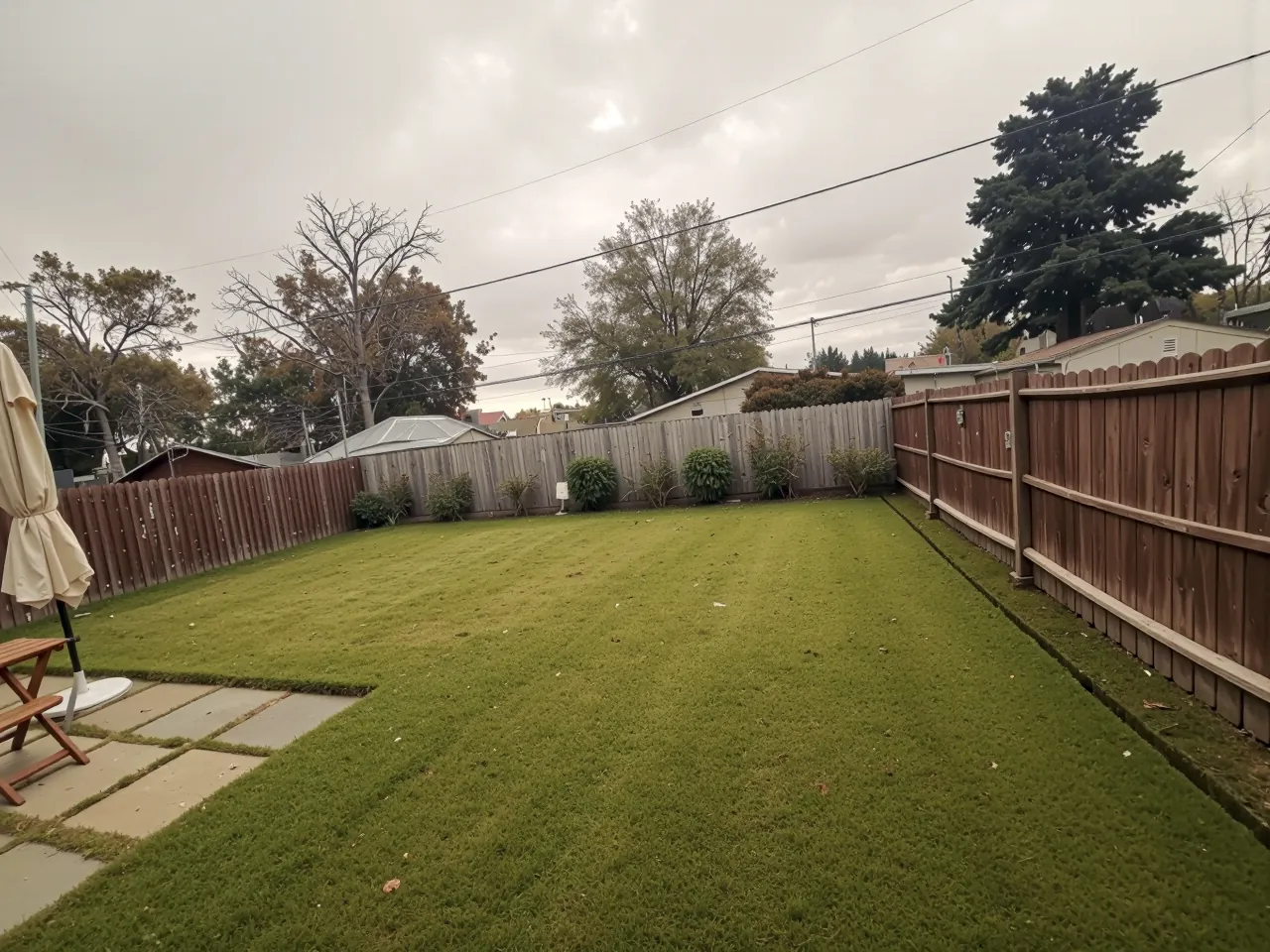 Backyard with fresh sod, paver stepping stones and a wood fence in Houston, TX